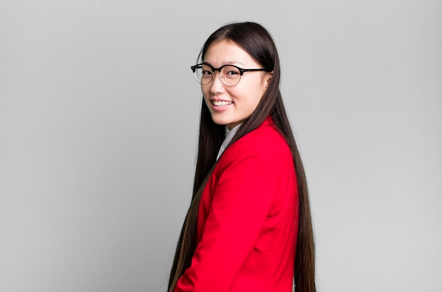 Adulto joven mujer de negocios bastante asiática con chaqueta roja y gafas