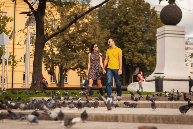 Adulto joven pareja enamorada juntos en el parque con palomas