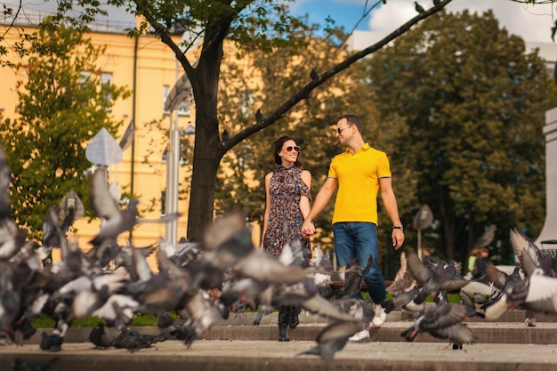 Adulto joven pareja enamorada juntos en el parque con palomas