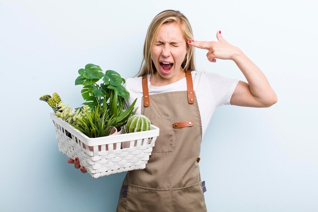 Adulto joven rubia jardinería con plantas