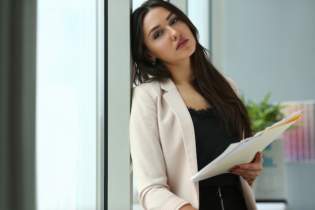 Adulto lindo sorriso feliz moda empresária cliente indiano ocupado fornecedor de prática de gestão em pé no local de trabalho do escritório. Segure a pasta com o despacho estatístico do rascunho em papel