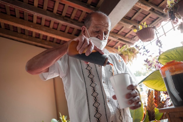 Adulto mayor mexicano preparando una bebida mexicana artesanal preparación de bebida tradicional mexicana bate