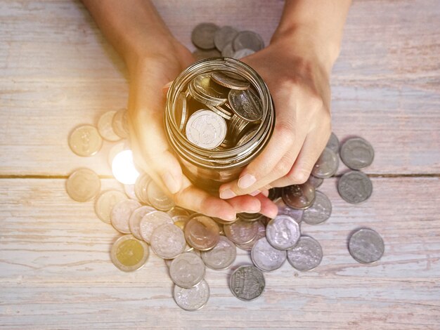 adulto sosteniendo dinero jar donación ahorro caridad concepto de plan de finanzas familiares