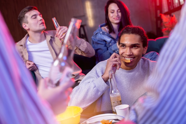 Foto adultos jóvenes que tienen una fiesta en casa