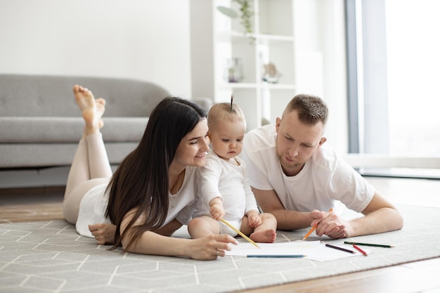 Adultos y niños dibujando garabatos en papel en casa