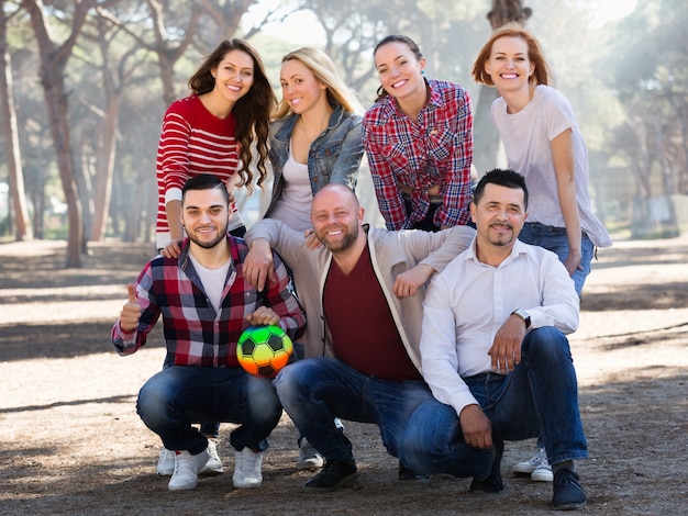 Foto adultos positivos persiguiendo pelota al aire libre