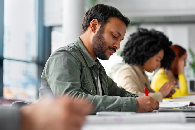 Foto adultos de tiro medio estudiando juntos