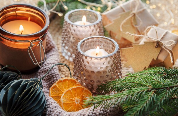 Foto adventsdekoration und geschenkboxen mit brennenden kerzen. weihnachtshintergrund