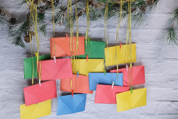 Adventskalender auf dem Hintergrund einer Backsteinmauer. Bunte Umschläge von Hand gefertigt.