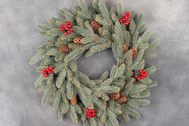 Foto adventskranz auf grauer tischdekoration weihnachtskranz mit roten beeren und tannenzapfen