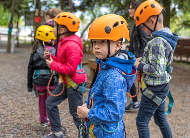 Adventure Climbing High Wire Park: niños en curso con casco de montaña y equipo de seguridad.