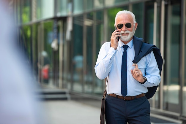 Advogado sênior falando ao telefone ao ar livre