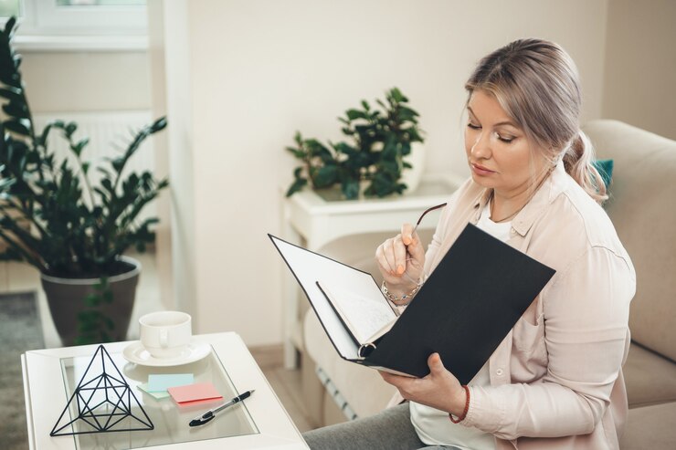 Foto ältere blonde kaukasische frau, die mit einigen unterlagen von zu hause aus arbeitet