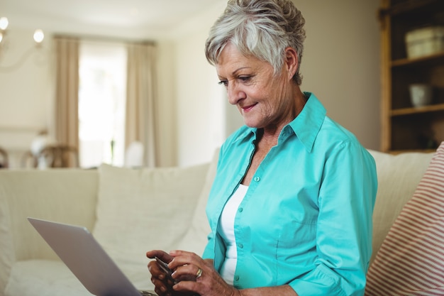 Ältere frau beim online-shopping auf dem laptop