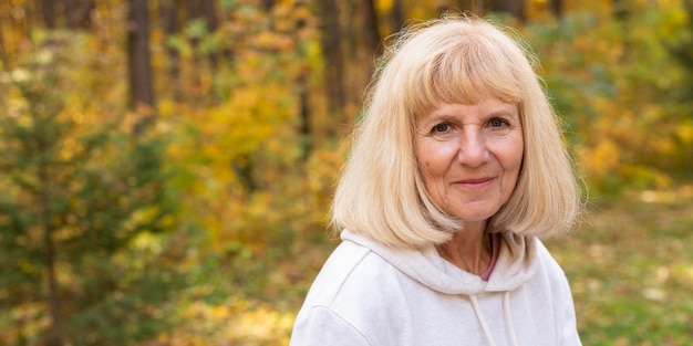 Foto Ältere frau, die draußen in der natur aufwirft