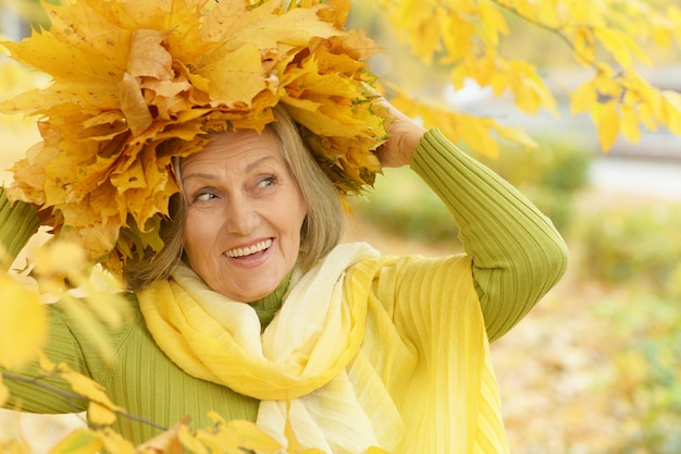 Foto Ältere frau, die im herbst im park spazieren geht