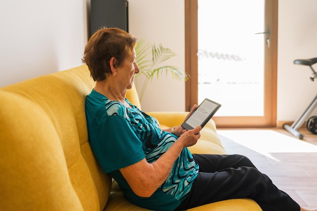 Foto Ältere frau, die mit ebook liest