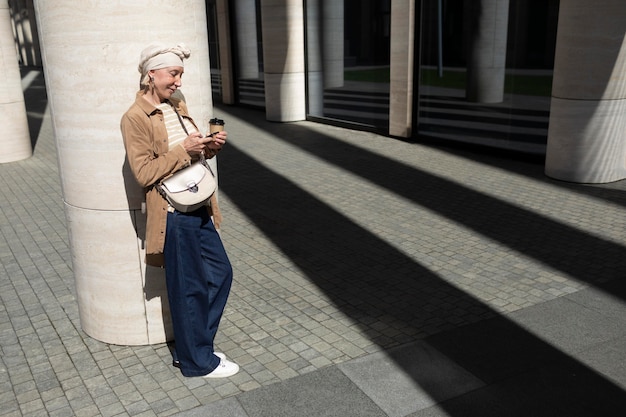 Foto Ältere frau mit smartphone im freien in der stadt