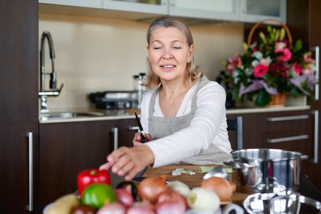 Foto Ältere frau zu hause kocht