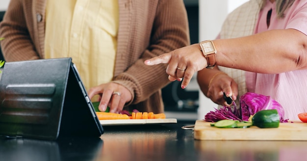 Foto Ältere hände und kochen in der küche mit tablet für das abendessen mittagessen oder gemüse mit unterstützung hilfe und liebe ältere mann und frau mit hinweis auf frieden und ernährung für bindung oder beziehung