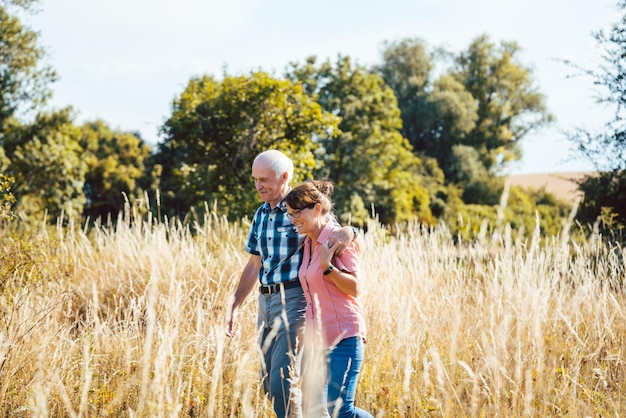 Ältere Menschen gehen auf dem Feld gegen Bäume