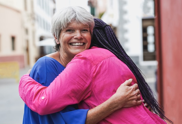 Ältere multirassische Frauen, die sich umarmen - Konzept von Freundschaft, Liebe und älteren Menschen