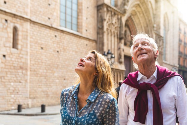 Ältere paare von den touristen, welche die alte stadt in barcelona besichtigen