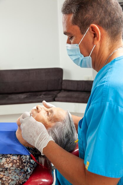 Foto Ältere patientin bei einem männlichen zahnarzt in mittlerem alter
