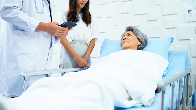 Foto Ältere patientin, die auf dem bett liegt, bekommt die kochsalzlösung und hört sich die ergebnisse eines männlichen facharztes an