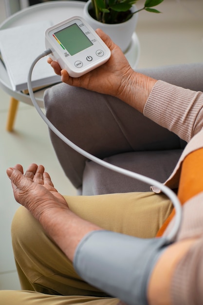 Foto Ältere person misst ihren blutdruck mit einem tensiometer