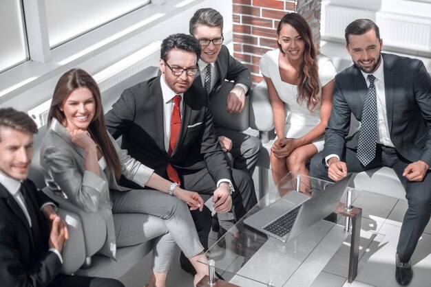 Älterer Geschäftsmann und Geschäftsteam sitzen in der Lobby des modernen Büros