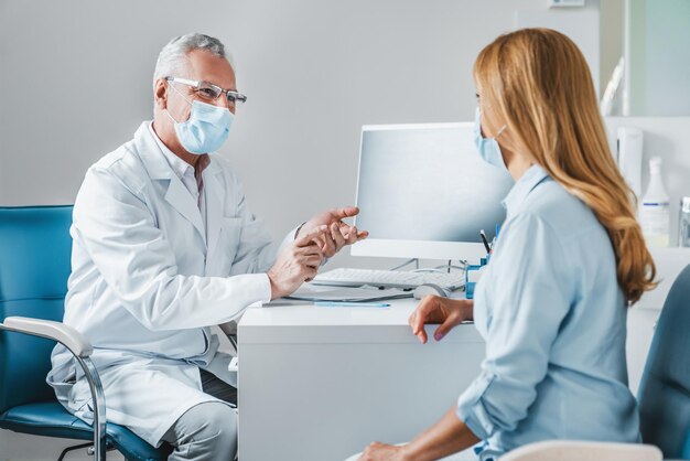 Foto Älterer männlicher arzt trägt eine schutzmaske und spricht mit einem patienten in der klinik.