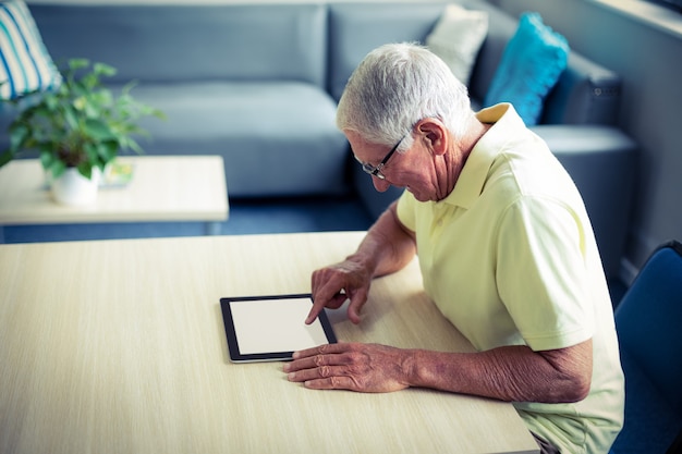 Älterer mann, der digitale tablette verwendet