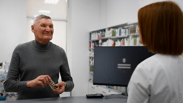 Foto Älterer mann, der medizin in der apotheke kauft
