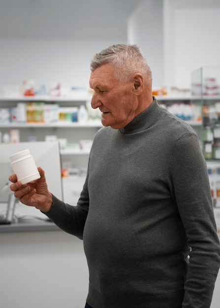 Foto Älterer mann, der medizin in der apotheke kauft