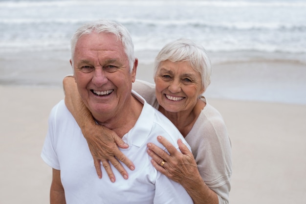 Älteres Paar, das sich am Strand umarmt