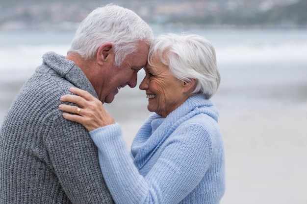 Älteres Paar, das zusammen am Strand steht