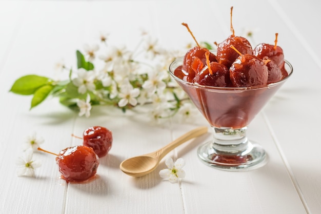 Äpfel marmelade und eine schüssel marmelade auf einem weißen holztisch. hausgemachte süßigkeiten nach alten rezepten.