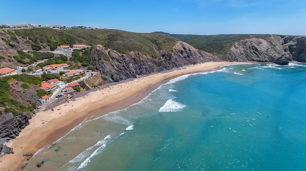 Aéreo. Turistas surfistas en la playa de Arrifana. Algarve