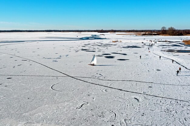 Aerial de vela de gelo e patinação no lago Bergumer no inverno na Frísia, na Holanda