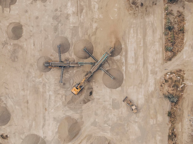 AERIAL SHOT Mini vestidor móvil en una obra. trituradora de piedra El proceso de triturar la piedra triturada en diferentes fracciones y clasificar en montones. Operación de excavadoras y niveladoras