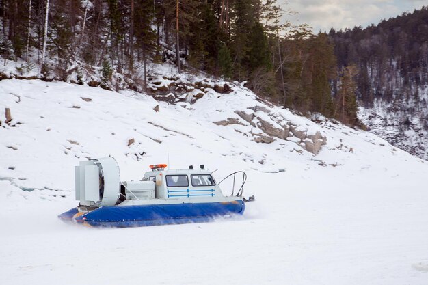 Un aerodeslizador se desliza sobre la superficie de un río helado Turismo de invierno