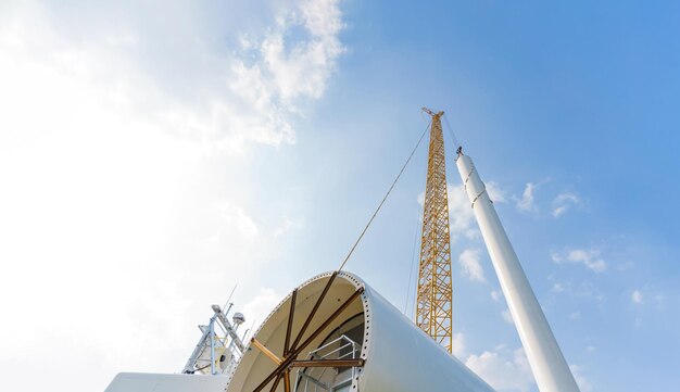 Un aerogenerador blanco con un cielo azul de fondo