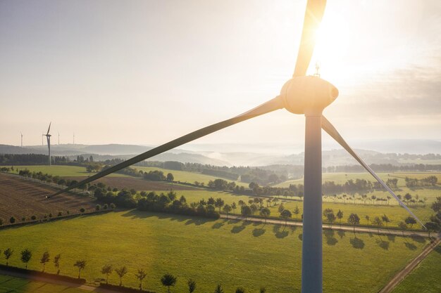 Aerogenerador y campos agrícolas en un día de verano - Producción de energía con energía limpia y renovable - toma aérea