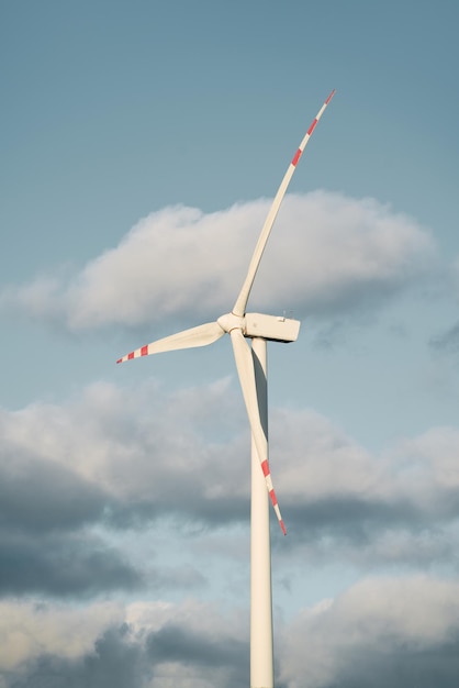 Aerogenerador contra el cielo azul en el sol vespertino Foto vertical