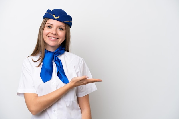 Aeromoça lituana de avião isolada em fundo branco apresentando uma ideia enquanto olhava sorrindo para