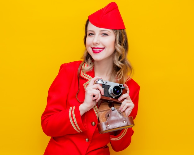 Aeromoça vestindo uniforme vermelho com câmera fotográfica