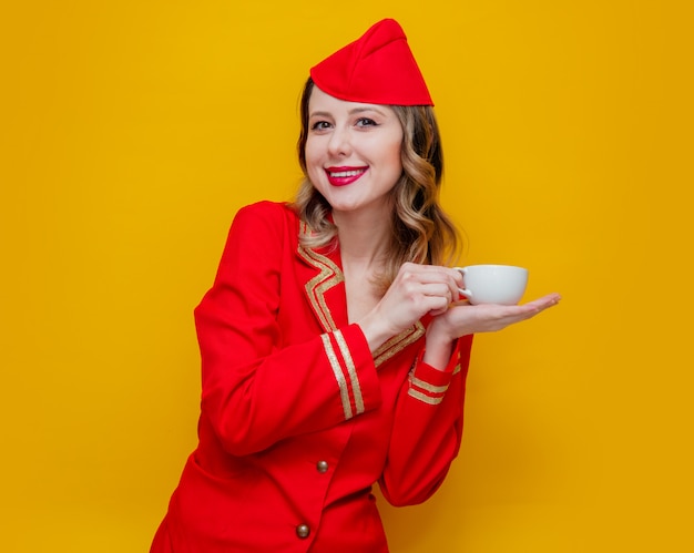 aeromoça vestindo uniforme vermelho com uma xícara de café ou chá