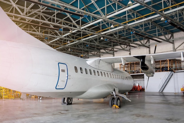 Aeronave turboélice branca de passageiros em manutenção no hangar