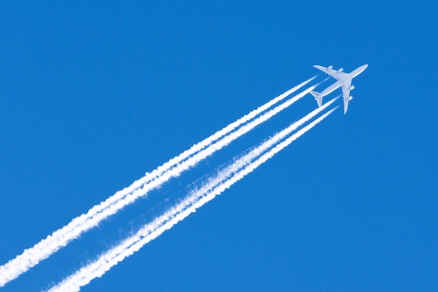 Aeroplano grande cuatro motores de la aviación aeropuerto estelas nubes.